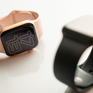 Two smartwatches in rose gold and black.